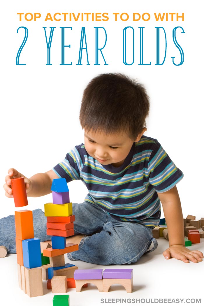 A little boy playing with blocks, participating in activities to do with 2 year olds
