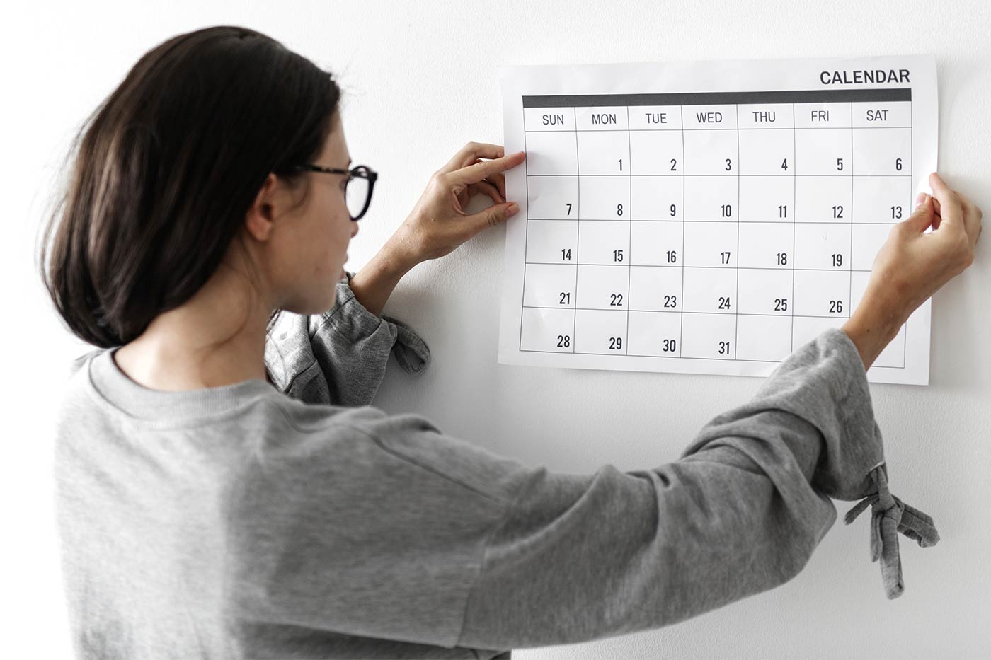 woman hanging a calendar