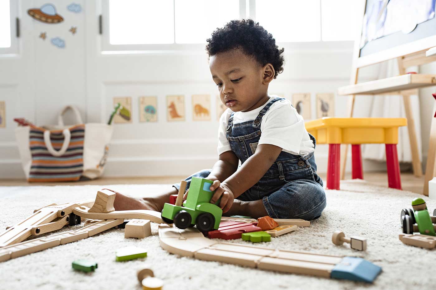 Little boy playing with wooden trucks